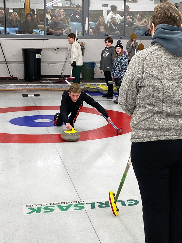 Barb Swallow checking on a proper curling delivery.”></a><br />
<p class=